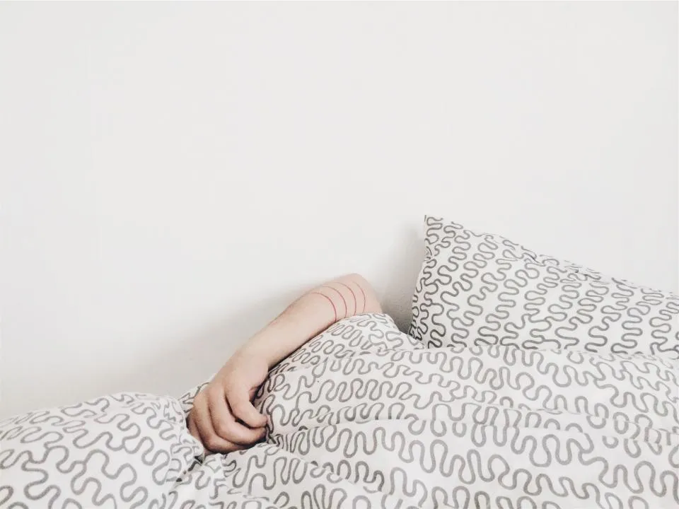 Adult sleeping peacefully in a bed with patterned bedding