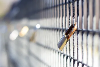 Padlock fastened to a metal fence, symbolising password security