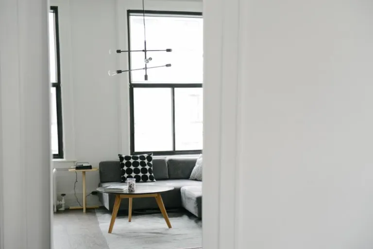 Tidy minimalist living room with grey sofa and round coffee table after decluttering