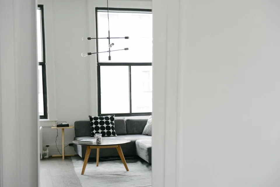 Tidy minimalist living room with grey sofa and round coffee table after decluttering
