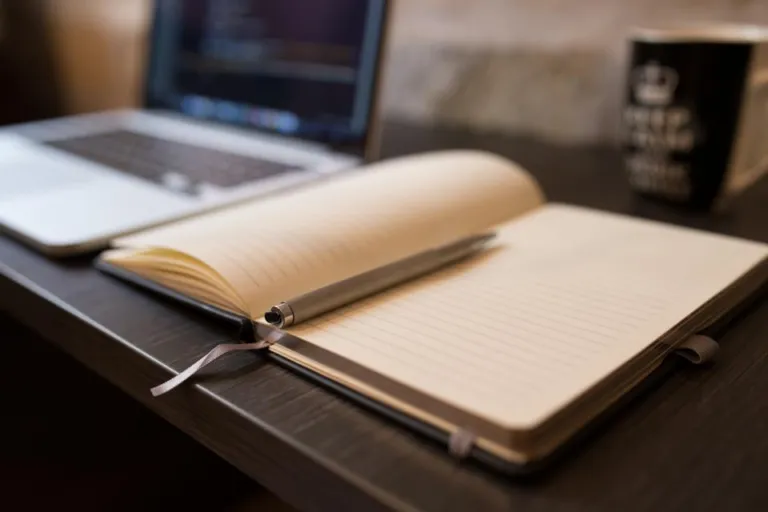 Open notebook and pen beside a laptop, ready for writing a simple business plan